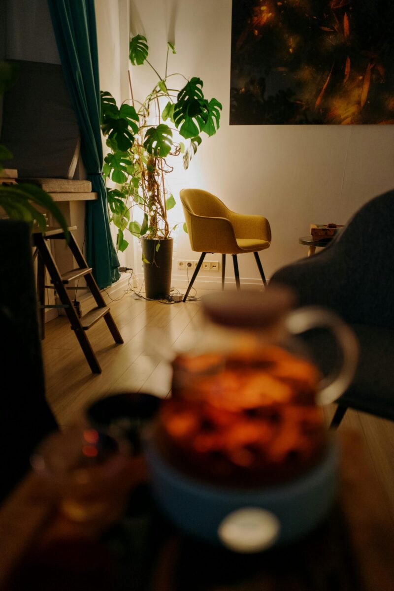 Warm and inviting living room with a yellow armchair, indoor plants, and soft lighting.